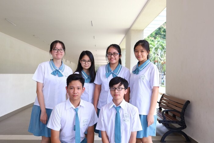 Đồng phục học sinh Đinh Thiện Lý với thiết kế áo sơ mi trắng kết hợp quần tây/chân váy xanh coban, tạo vẻ thanh lịch và hiện đại.